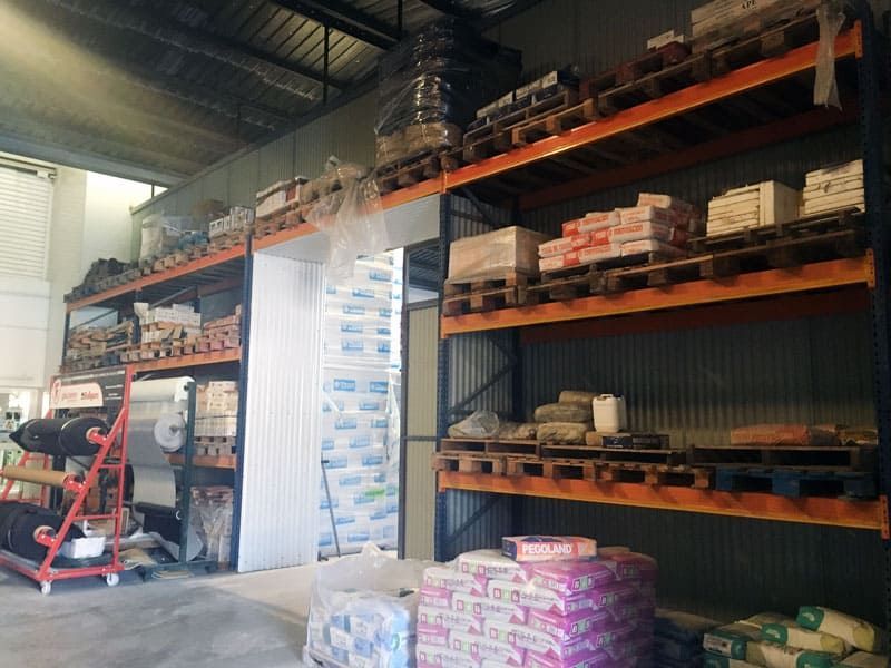 Un almacén lleno de muchos estantes y bolsas de cemento.