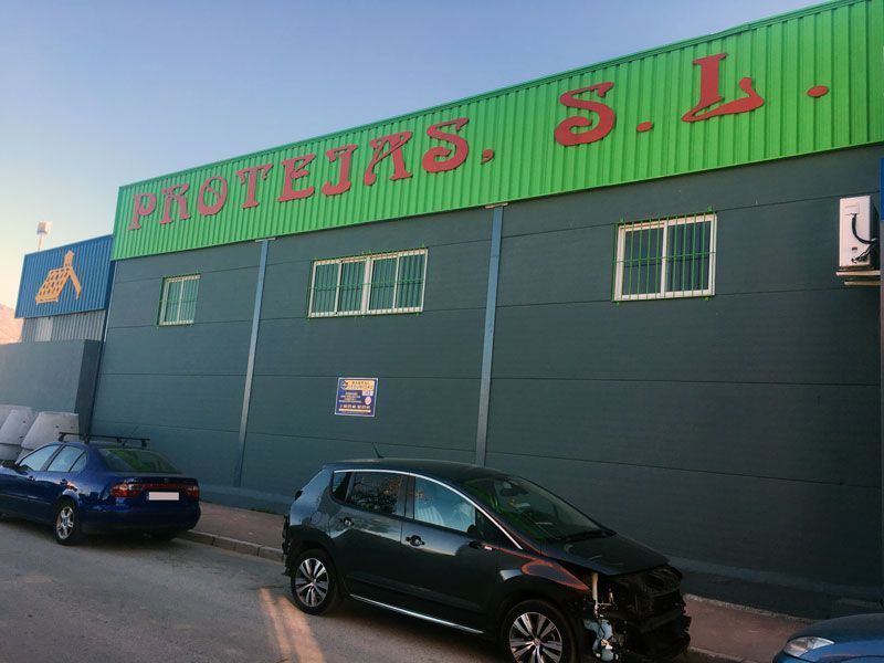 Un coche negro está aparcado delante de un edificio que dice protejas sl