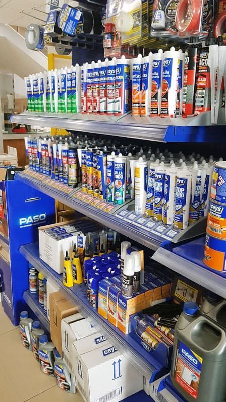 Un estante de una tienda lleno de muchas botellas de pegamento