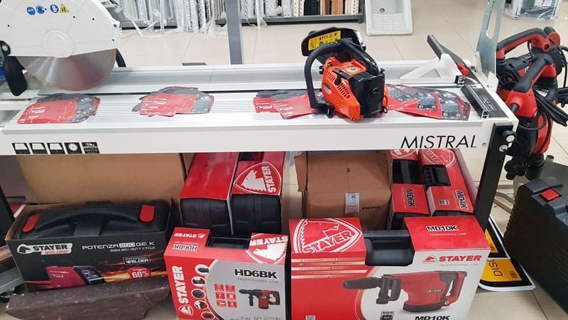 Un estante lleno de cajas de herramientas y una motosierra.