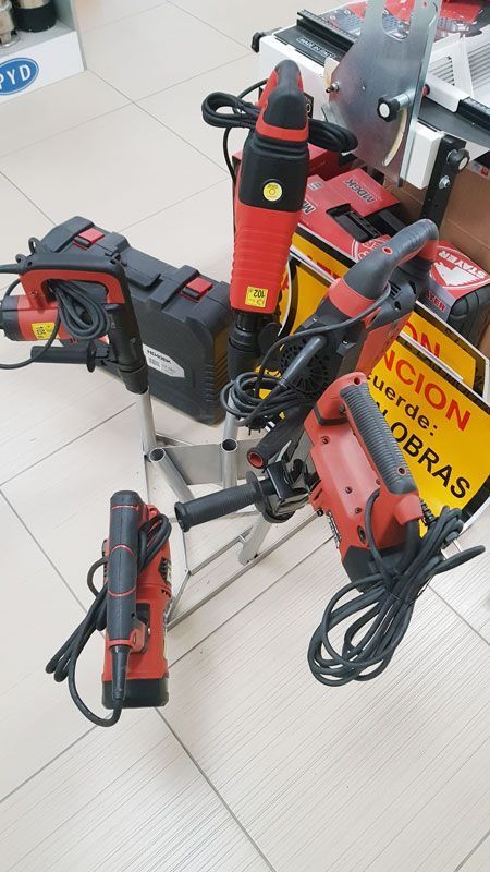 Un montón de herramientas están apiladas una encima de otra sobre un piso de baldosas.