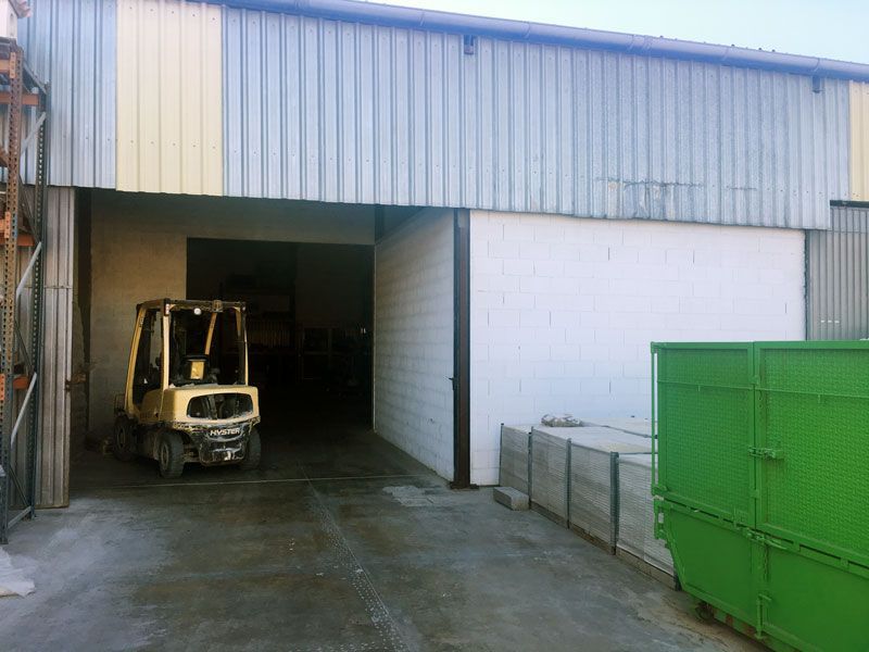 Una carretilla elevadora amarilla está estacionada afuera de un edificio