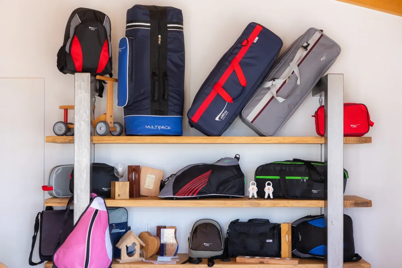 Regal mit Taschen, Koffern und kleinen Werkzeugen, angeordnet in einer Garage oder einem Abstellraum