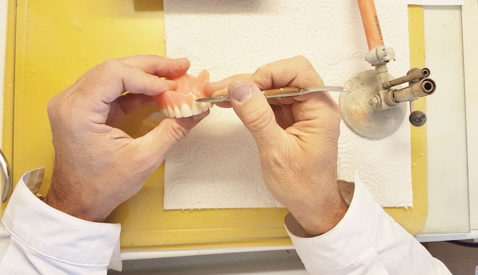 Un dentiste travaille sur un modèle de dent.