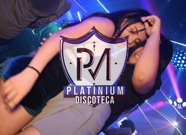 Dos personas abrazándose en Discoteca Platinium, ambiente oscuro con un logo en la foto.