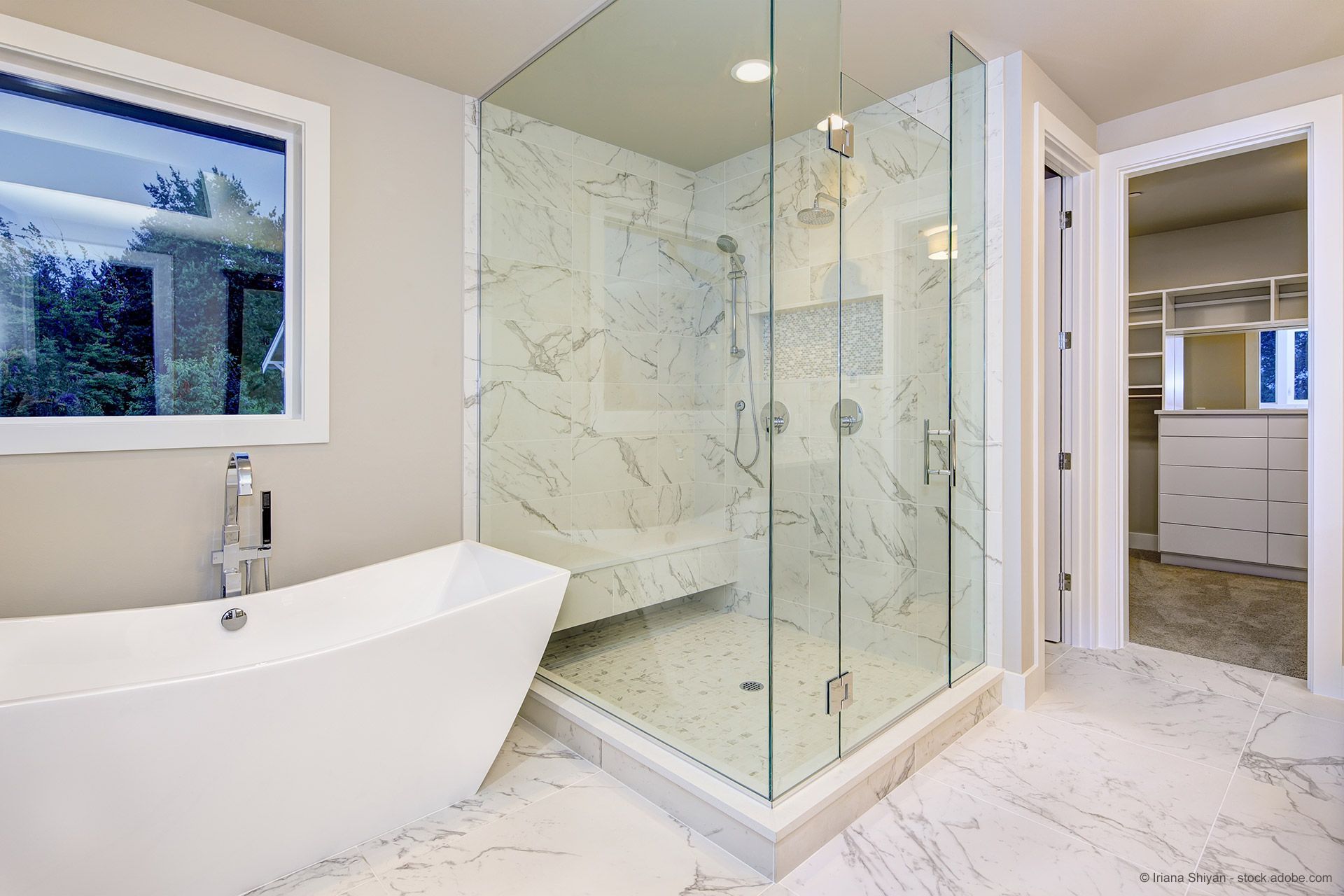 Modernes Badezimmer mit Glasdusche, Badewanne und Marmorfliesen.