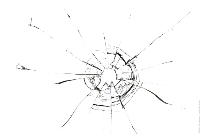 Zersplittertes Glas mit einem zentralen Aufprallpunkt und strahlenförmigen Rissen.
