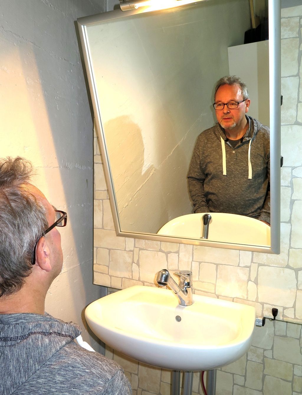 Barrierefreier Kippspiegel, per Fernbedienung nach vorne geneigt für optimale Sicht im Sitzen.
