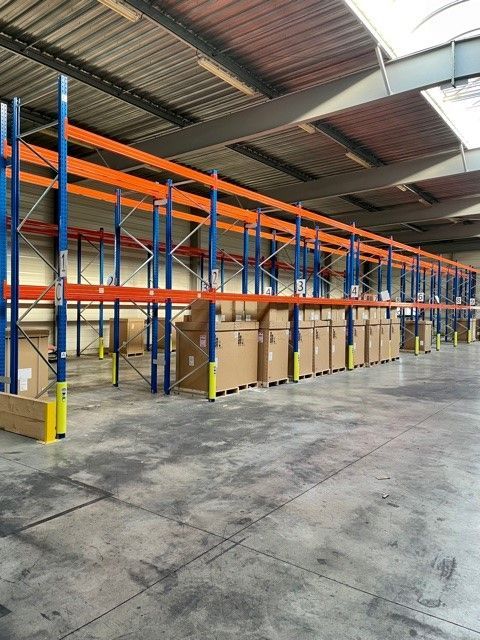 Entrepôt vide avec des étagères industrielles orange et bleues