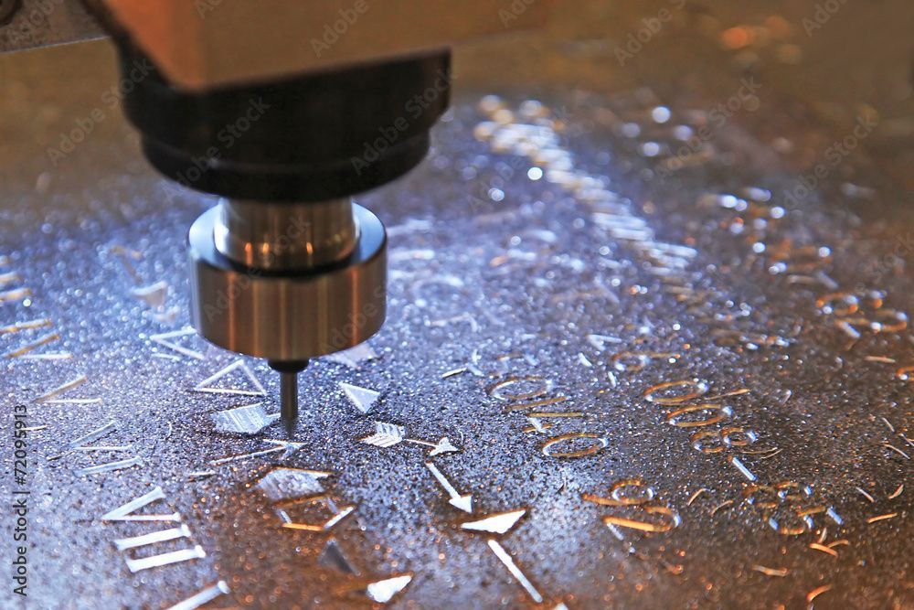 CNC-Maschine schneidet ein Zifferblatt aus Metall, die Schneidemaschine ist in Aktion.