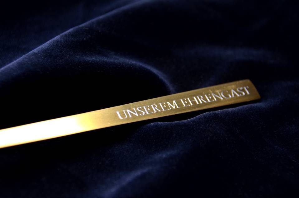 Goldene rechteckige Plakette mit der eingravierten Inschrift 