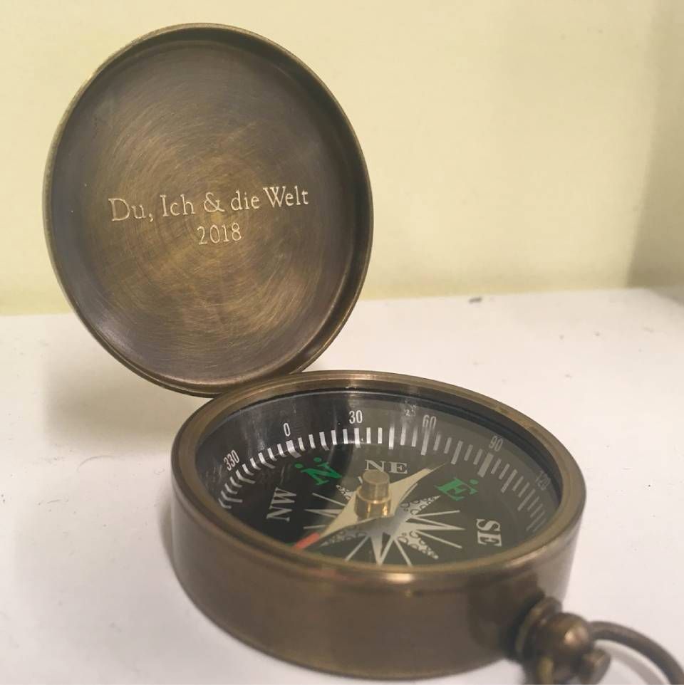 Brass compass with open lid; engraved German text 