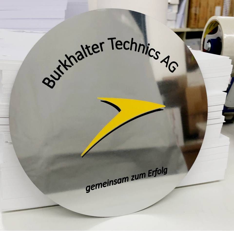 Round silver sign with black text 