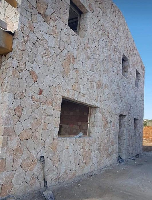 Un muro de piedra con una pala delante