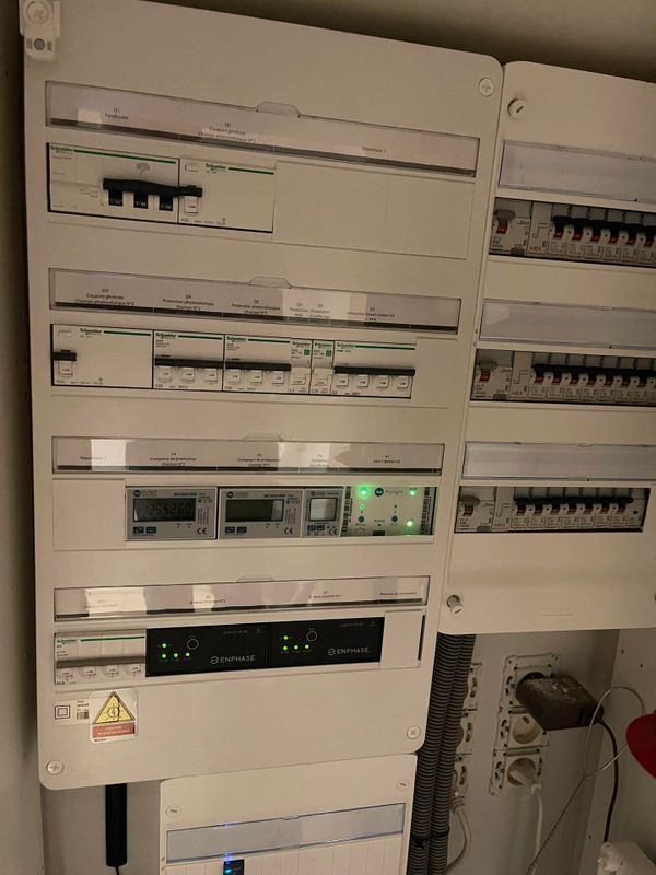 Tableau électrique avec plusieurs interrupteurs, un écran et une prise de courant.