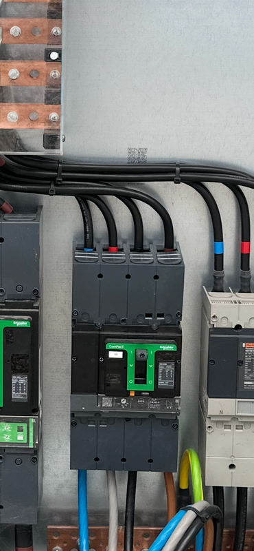 Panneaux solaires sur un toit de tuiles rouges, ciel ensoleillé en arrière-plan.