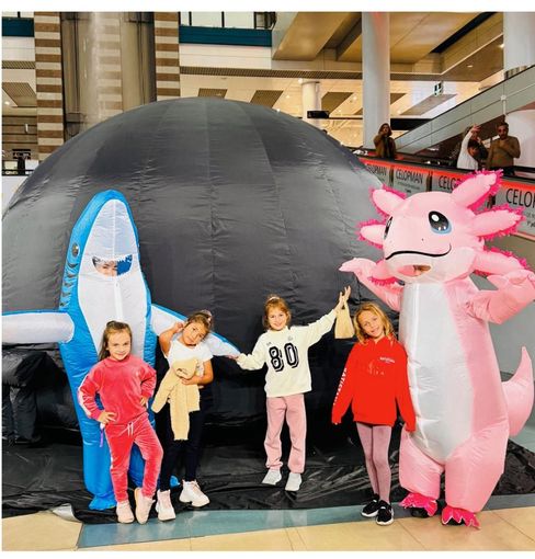 Dos mujeres están de pie delante de una gran cúpula.