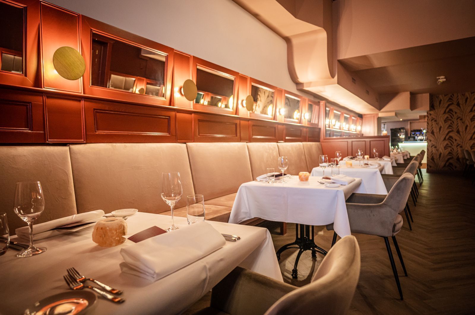 Een restaurant met tafels en stoelen die klaar staan ​​voor een maaltijd.