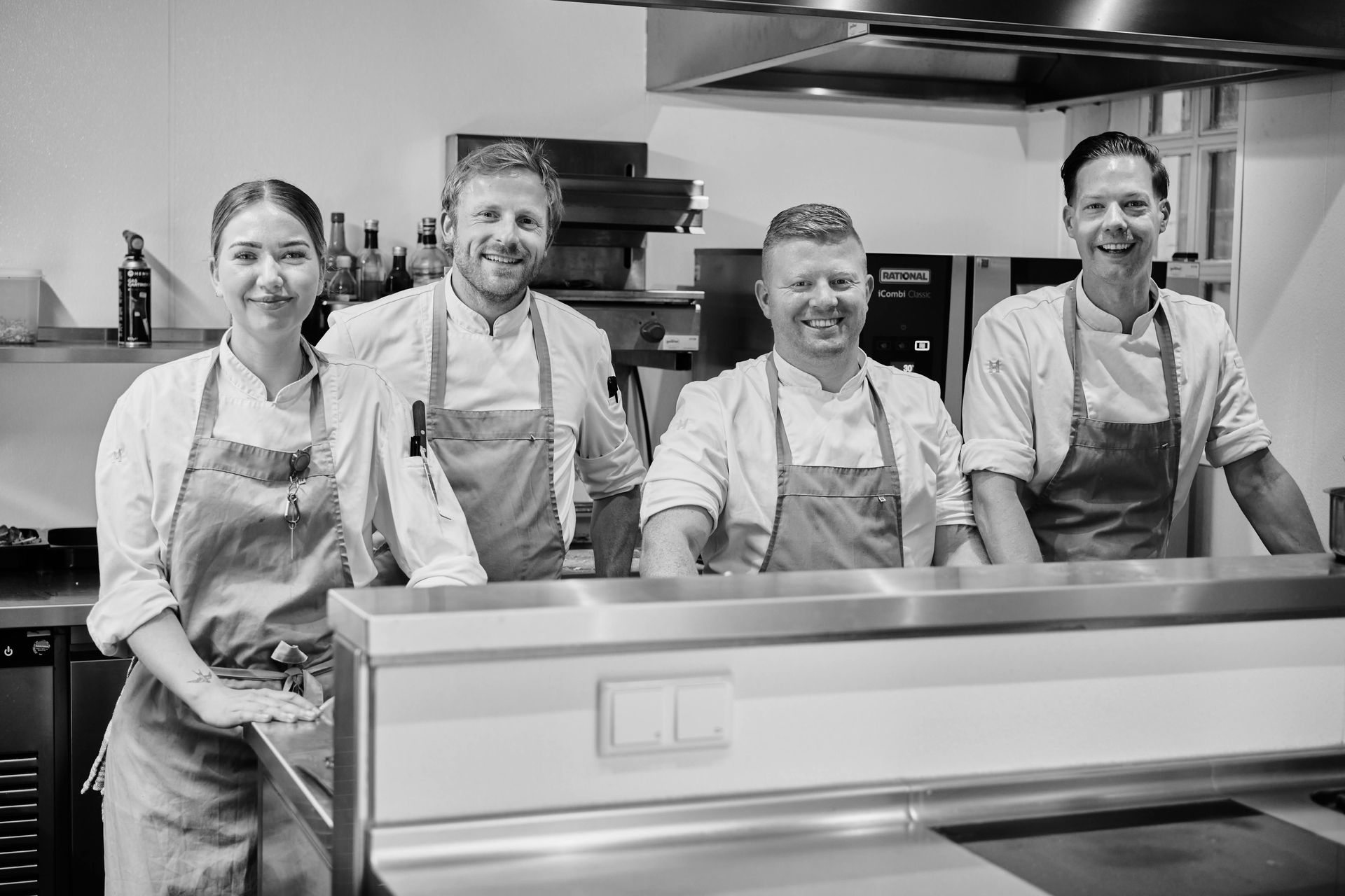 Een groep koks poseert voor een foto in een keuken.