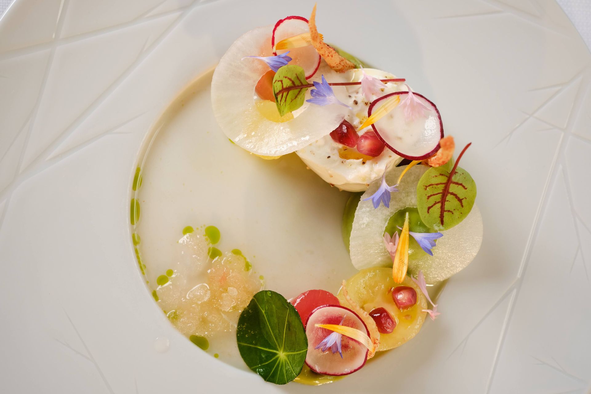 Een wit bord belegd met verschillende soorten fruit en groenten.