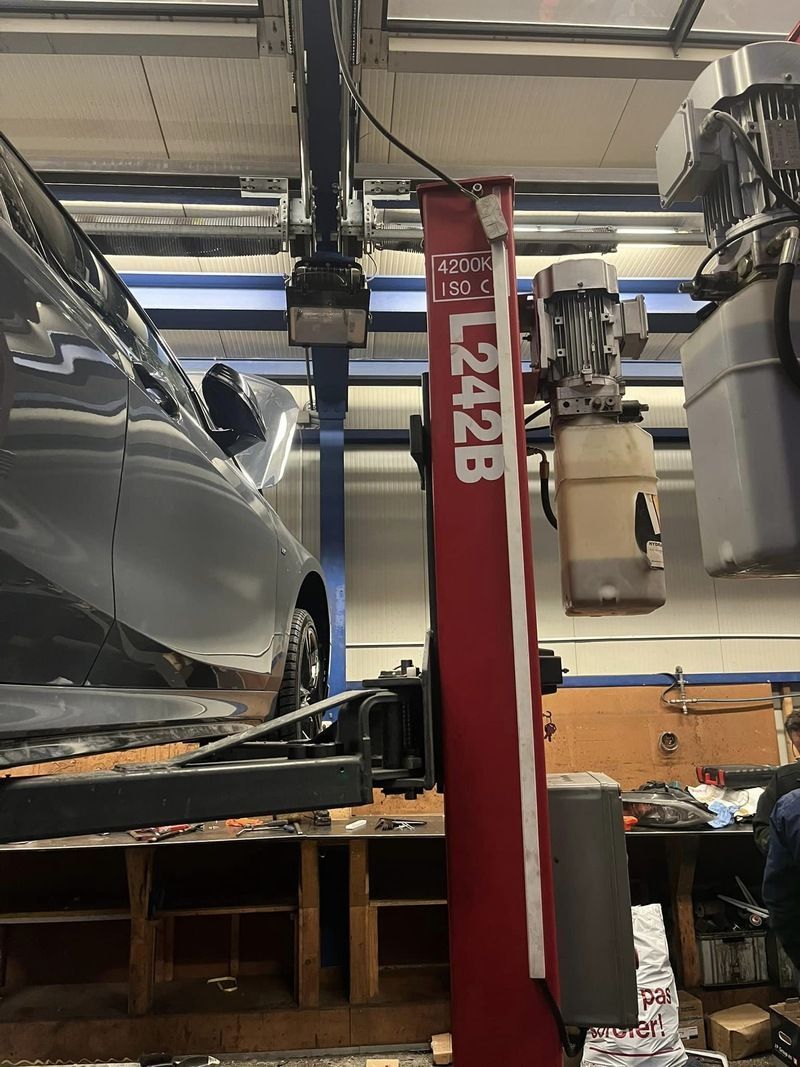 Une voiture est assise sur un ascenseur dans un garage.