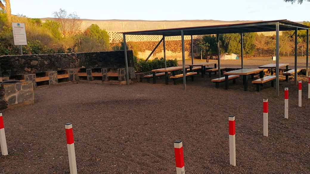 Un grupo de postes rojos y blancos están sentados en un campo de tierra.