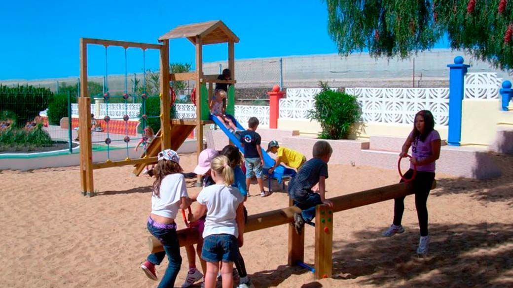 Un grupo de niños está jugando en un balancín en un patio de recreo.