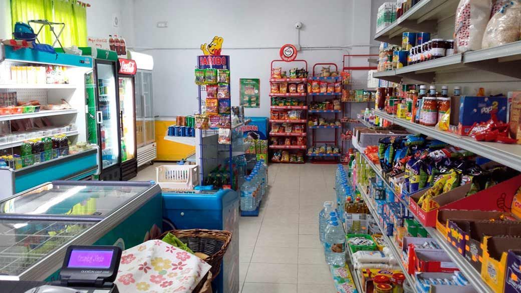 El interior de una pequeña tienda de comestibles llena de muchos productos.