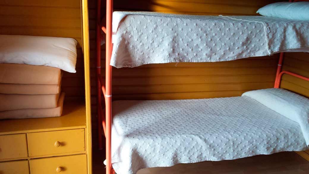 Una habitación con tres literas y una cómoda.