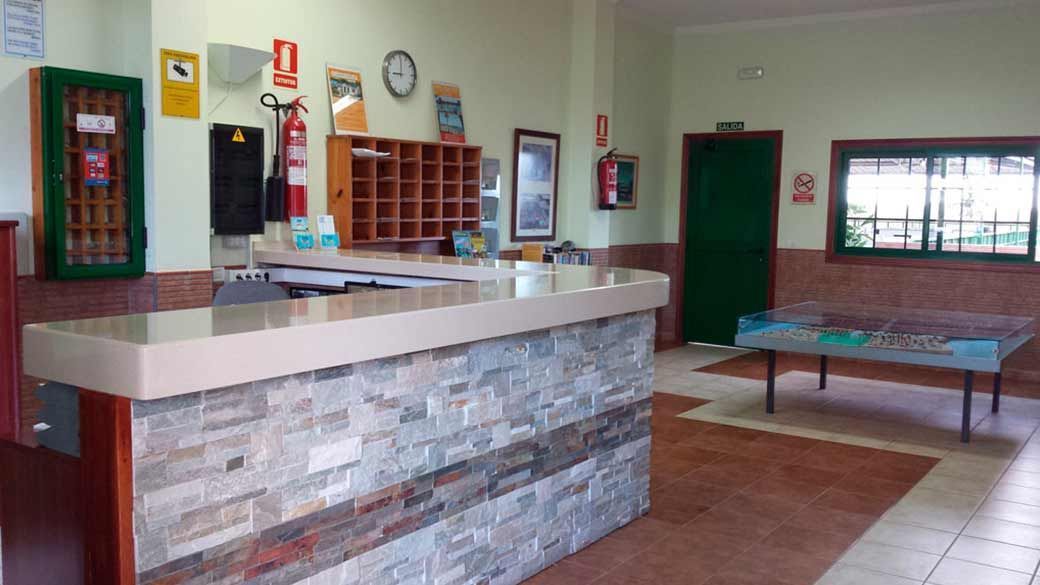 Un vestíbulo de hotel con un mostrador de piedra y una mesa.