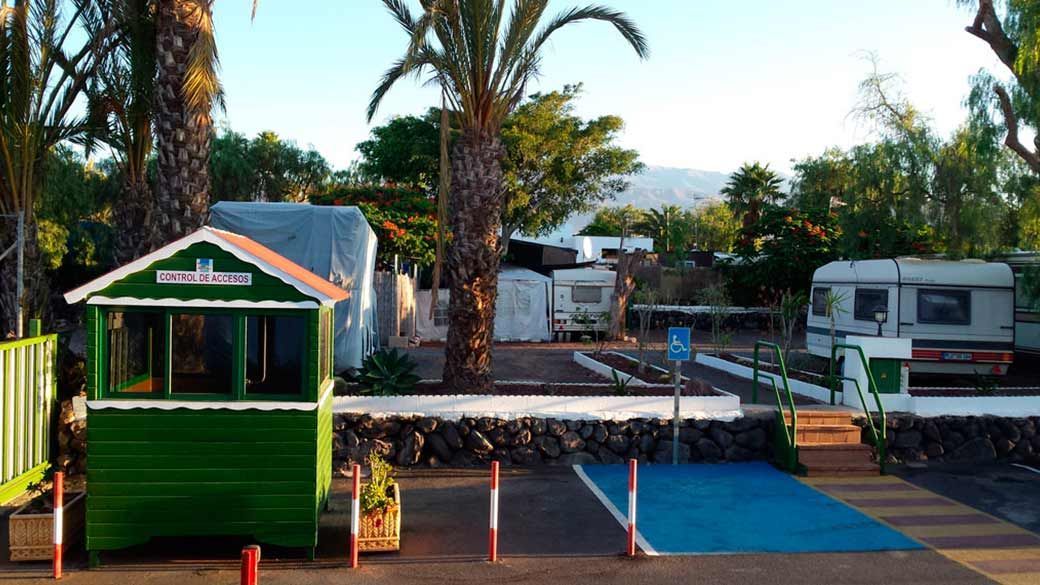 Un quiosco verde está situado en el medio de un estacionamiento.