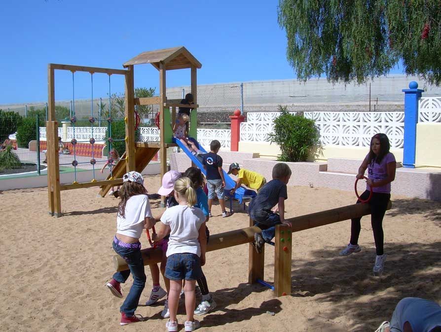 Un grupo de niños está jugando en un balancín de madera.