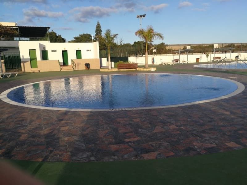 Una gran piscina circular con un edificio al fondo.