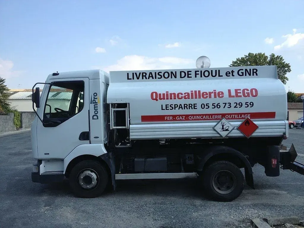 Camion-citerne blanc stationné à l'extérieur avec l'inscription « Livraison de fioul et GNR ».