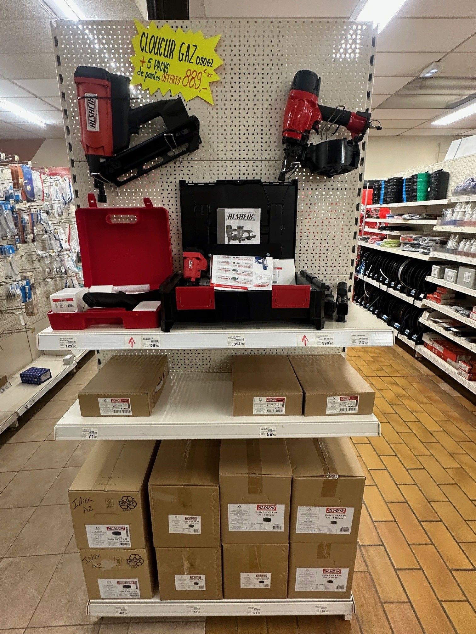 Présentoir de quincaillerie avec cloueuses et boîtes.