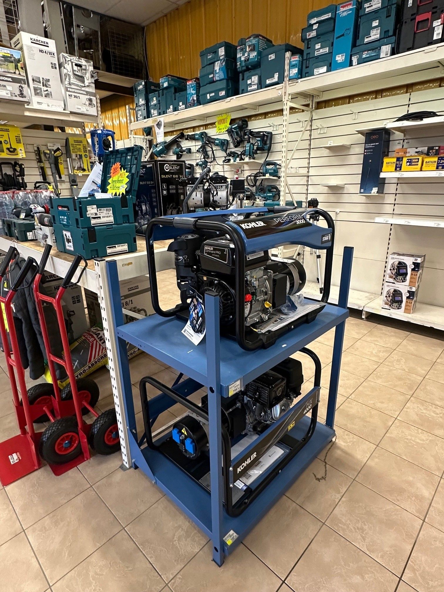 Deux générateurs Kohler bleus sur une étagère métallique bleue dans un magasin.