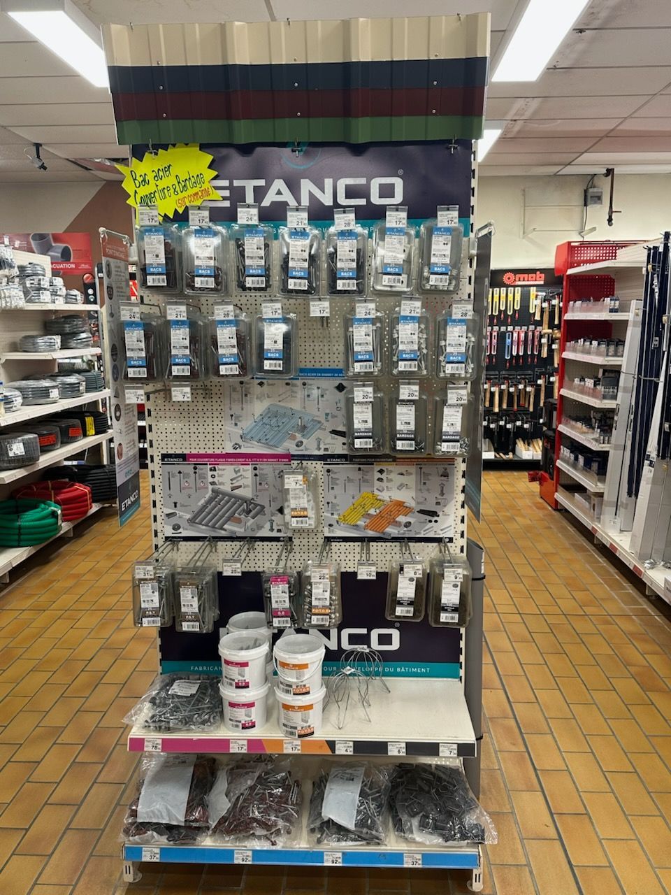 Présentoir de vente de produits Betanco, mettant en scène divers outils dans un environnement de magasin.