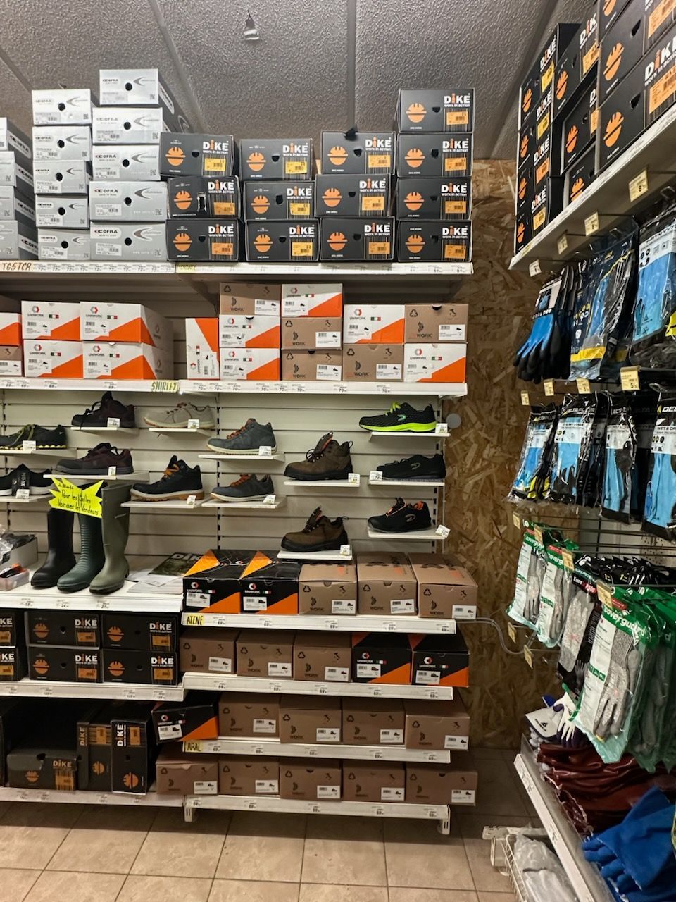 Des étagères remplies de bottes de travail et de boîtes dans un magasin.