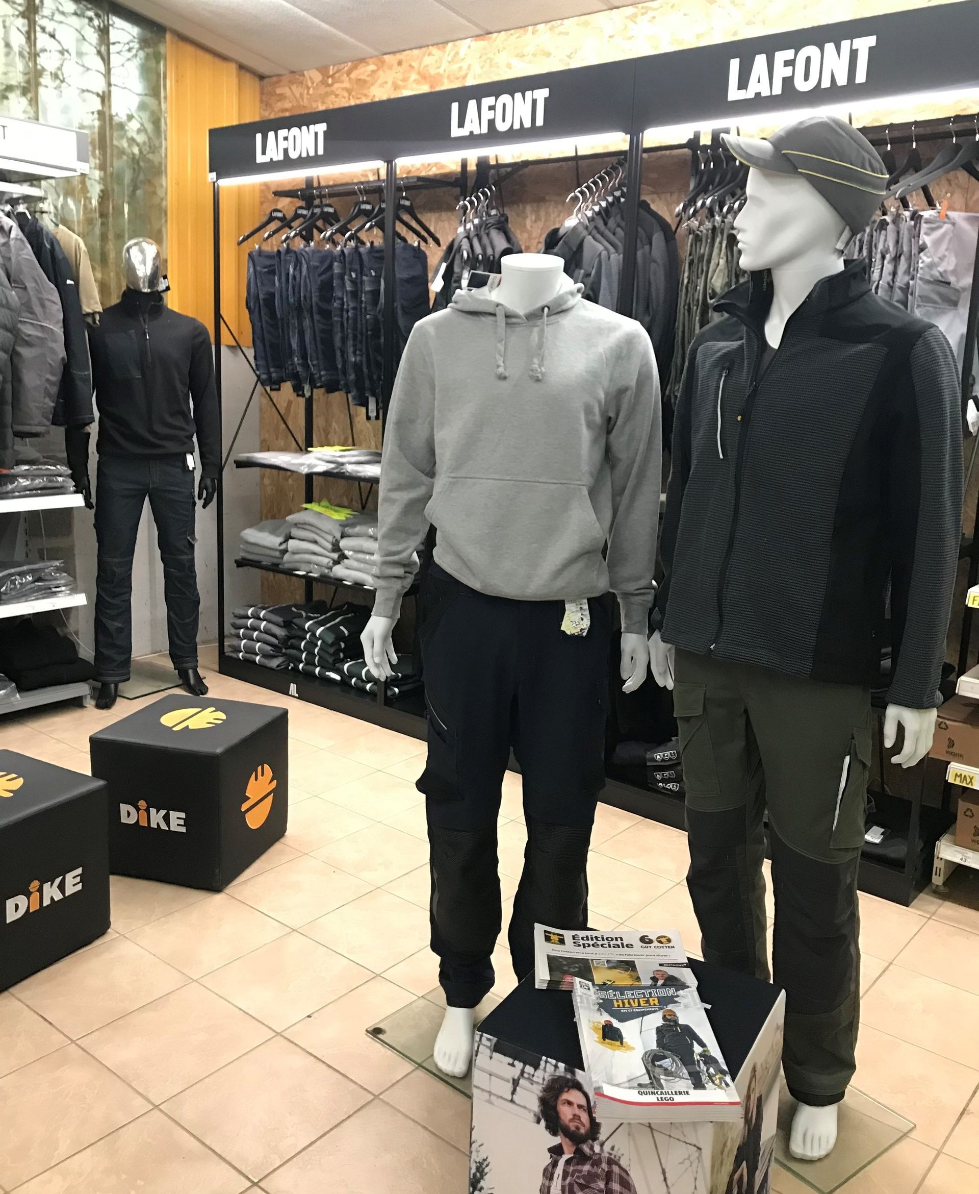 Magasin de vêtements avec mannequins en tenue de travail. Enseigne LAFONT et produits sur les étagères.