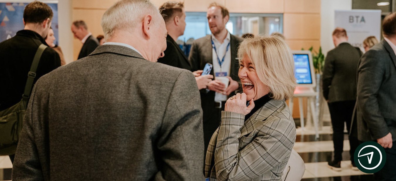 People at a business event laughing and talking.