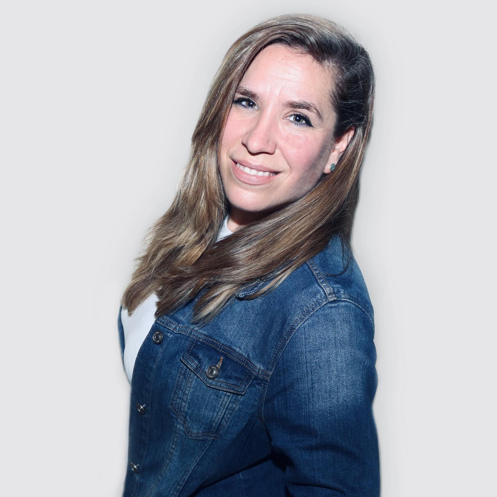 Una mujer con cabello rizado se está tomando un selfie en un dormitorio.