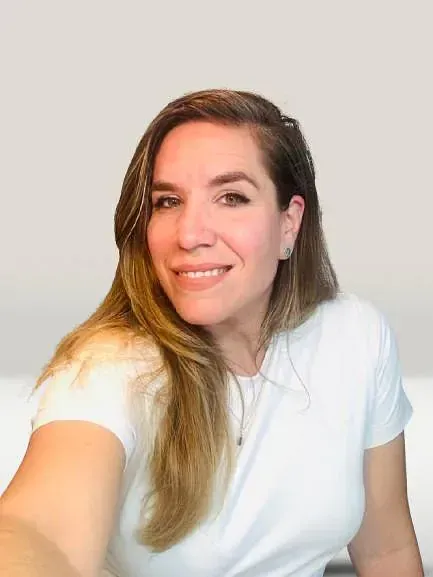 Una mujer con una camisa blanca se está tomando un selfie.