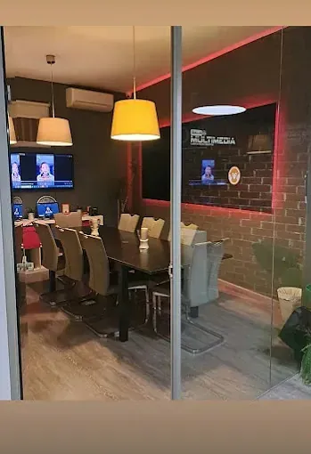 Una sala de conferencias con una mesa y sillas y una pared de ladrillos.