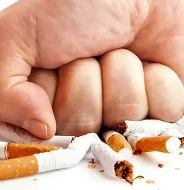 Una persona sostiene un montón de cigarrillos rotos en su puño.
