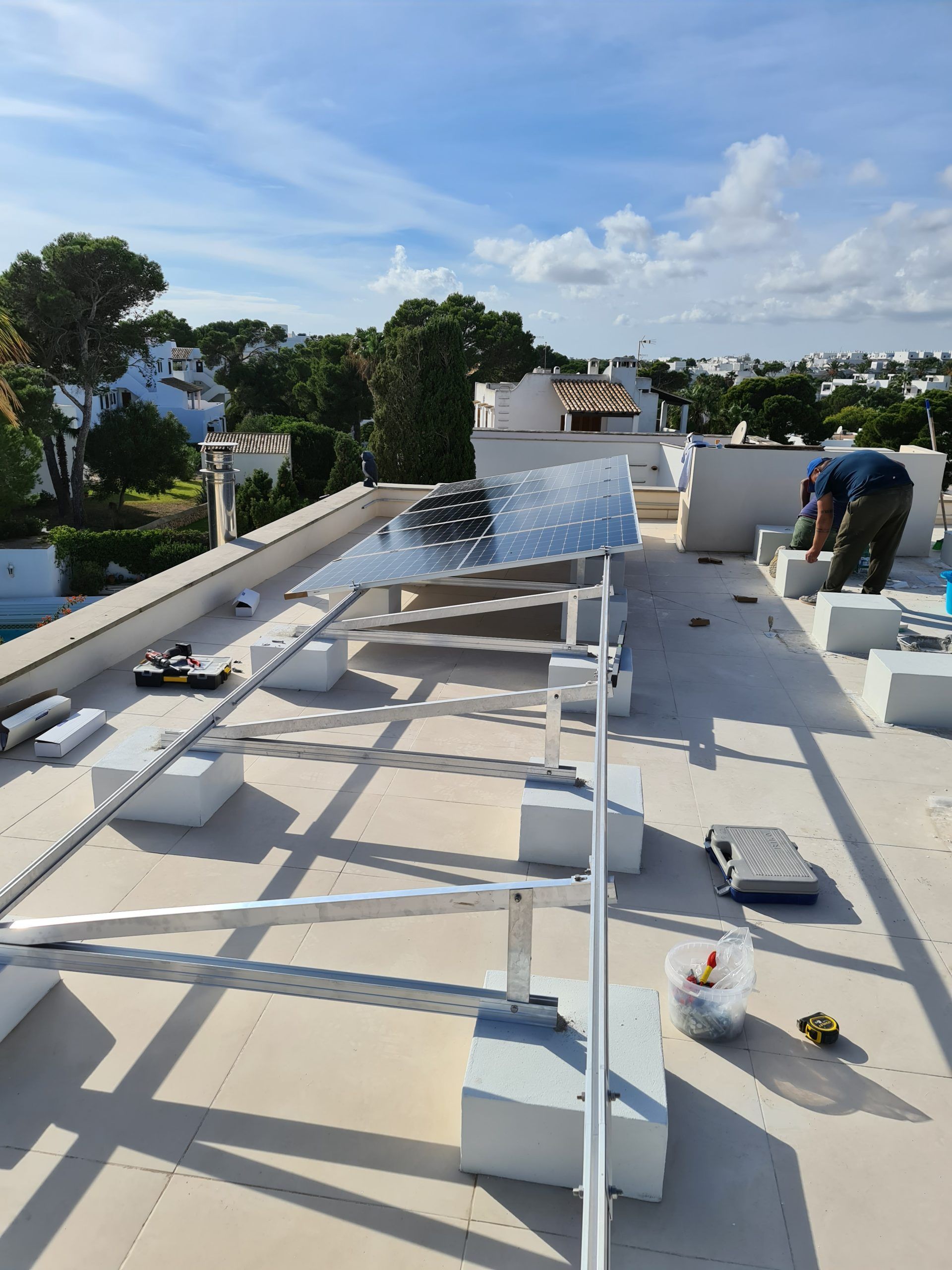 Un hombre está trabajando en un panel solar en el tejado de un edificio.