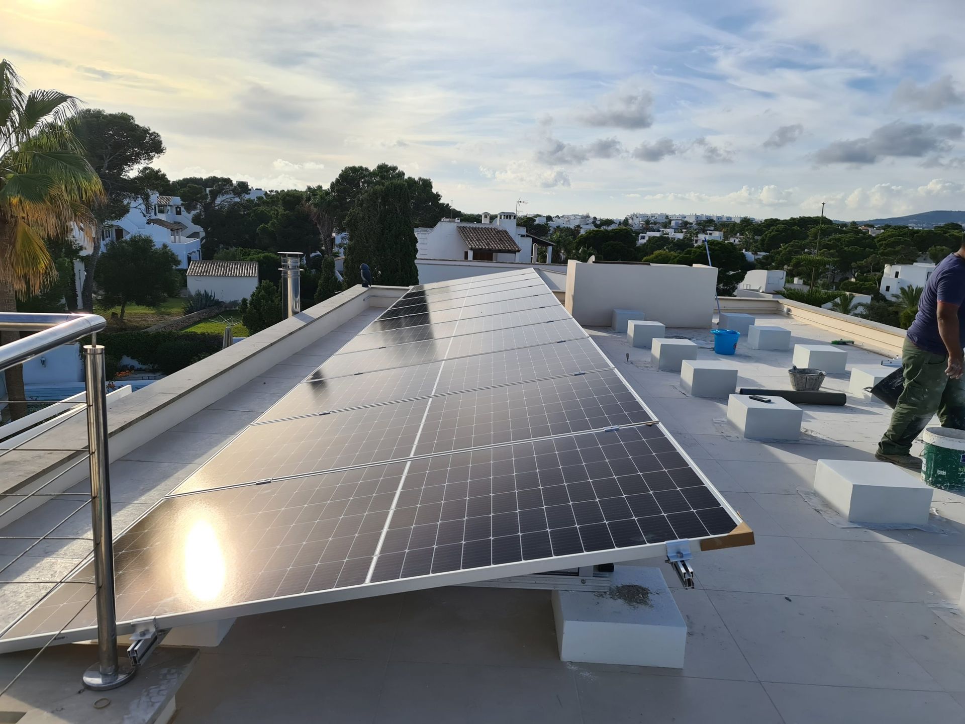 Una fila de paneles solares están colocados encima de un tejado.