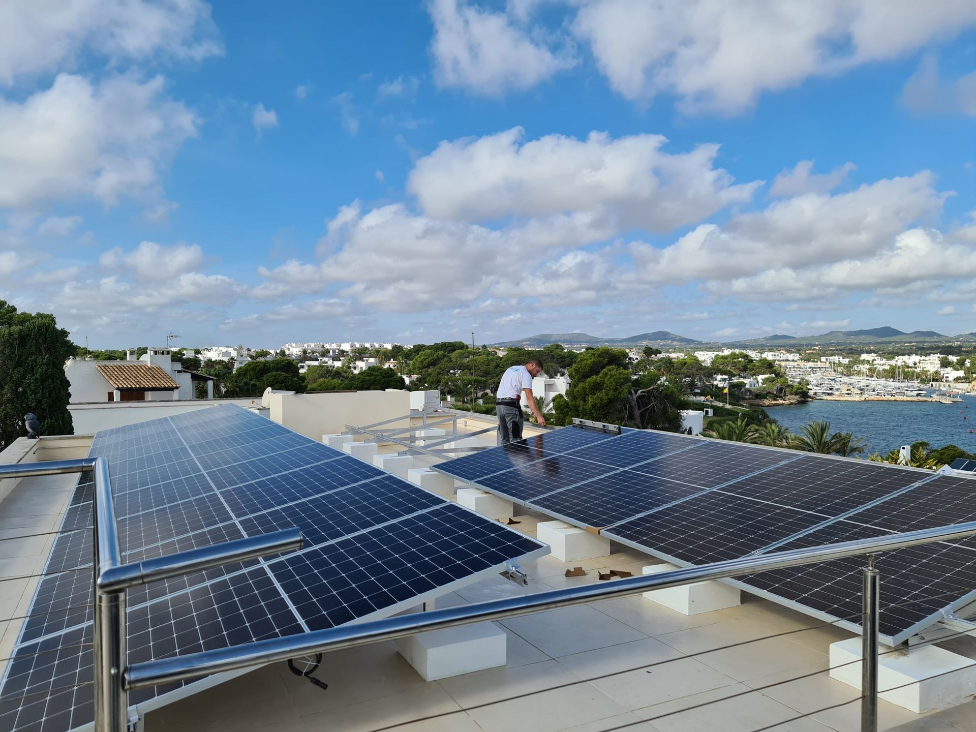 Un hombre está parado encima de un tejado con paneles solares.
