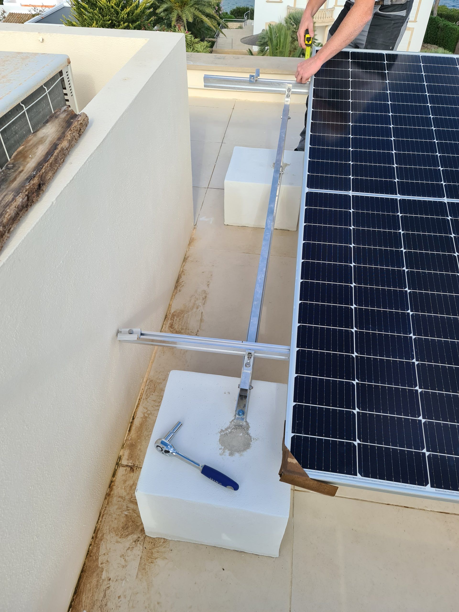 Un hombre está trabajando en un panel solar en un tejado.