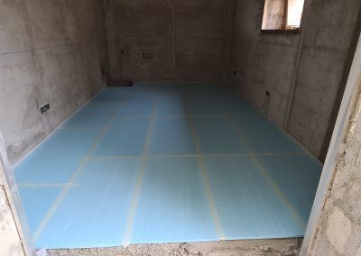 Una habitación con suelo azul y pared de hormigón.