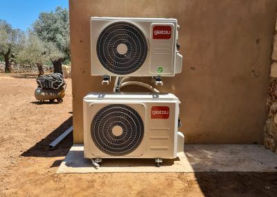 Dos acondicionadores de aire están apilados uno encima del otro en el costado de un edificio.